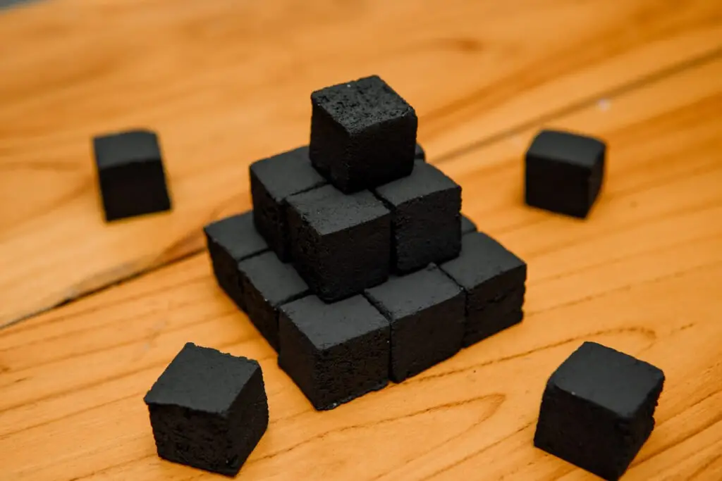 pyramid of coconut charcoal briquettes on wooden table